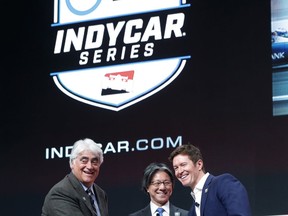 FILE - In this Jan. 15, 2019, file photo, from left, IndyCar CEO Mark Miles, Tsuneshia Okuno, an executive vice president at NTT and 2018 series champion Scott Dixon shake hands during a news conference at the North American International Auto Show in Detroit. Deals done since Scott Dixon wrapped up his fifth IndyCar championship last September include new title sponsorship from Japanese communications giant NTT, the transition to a single steady television partner in NBC Sports and a push toward expanding the grid that has made it easier for new teams to crack into the series.