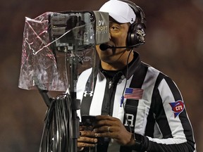 FILE - In this Nov. 3, 2018, file photo, referee Reggie Smith reviews a targeting penalty during the first half of an NCAA college football game between Oklahoma and Texas Tech, in Lubbock, Texas. The NCAA football rules committee has proposed giving replay officials more leeway to overturn targeting fouls. The rules committee met in Indianapolis this week and announced on Friday, March 1, 2019, its proposed changes. The proposals must be approved by the football oversight committee in April. They would go into effect next season.