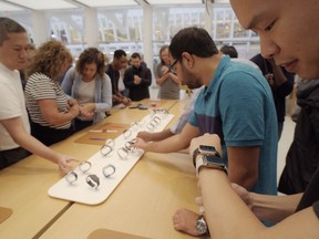 FILE- In this Sept. 21, 2018 file photo customers look at Apple Watches at an Apple store in New York. A huge study suggests the Apple Watch sometimes can detect a worrisome irregular heartbeat. But experts say more work is needed to tell if using wearable technology to screen for heart problems really helps.