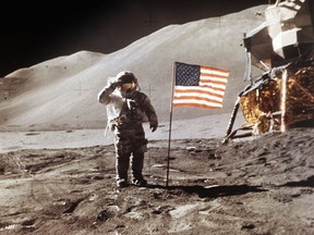 FILE - In this July 30, 1971 photo made available by NASA, Apollo 15 Lunar Module Pilot James B. Irwin salutes while standing beside the fourth American flag planted on the surface of the moon. On Tuesday, March 26, 2019, Vice President Mike Pence called for landing astronauts on the moon within five years. (NASA via AP)