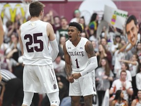 Colgate guard Jordan Burns (1) celebrates a basket with forward Rapolas Ivanauskas (25) during the first half of an NCAA college basketball game against Bucknell for the championship of the Patriot League men's tournament in Hamilton, N.Y., Wednesday, March 13, 2019.