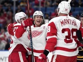 Detroit Red Wings left wing Tyler Bertuzzi, center, celebrates his goal with center Dylan Larkin, left, and right wing Anthony Mantha during the first period of the team's NHL hockey game against the Buffalo Sabres in Buffalo, N.Y., Thursday, March 28, 2019.