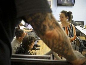 In this Friday, March 15, 2019 photo, Laura Levine, right, meets with client patients at Vocal NY, an organization that works with addicts, where she is the health educator and coordinator for the opioid reversal drug Narcan, in the Brooklyn borough of New York. New York state is considering providing medication-assisted treatment to all prison and jail inmates struggling with opioid addiction.