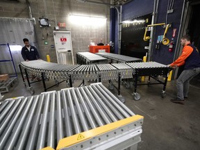 FILE - In this Nov. 9, 2018, file photo, Laurence Marzo, left, and Ty Ford, right, move a conveyor belt into place to help unload a truck carrying merchandise at a Walmart Supercenter in Houston. Ford has worked at Walmart in Houston for eight years, most recently overseeing workers tasked with unloading the trucks. On Tuesday, March 5, 2019, the Institute for Supply Management, a trade group of purchasing managers, issues its index of non-manufacturing activity for February.