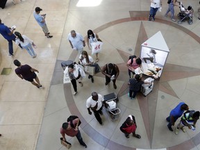 FILE- In this Nov. 23, 2018, file photo shoppers walk through Dolphin Mall in Miami. The 2018 holiday season turned out to be a mixed bag for retailers, with some of them defying a gloomy government report in December that raised concerns that shoppers were hunkering down everywhere. Mall-based clothing chains and department stores, particularly those that target the middle-income shoppers, continue to muddle along. Macy's had weak holiday sales, ending a year-long recovery after a three-year slump. J.C. Penney and Gap are both closing more stores after lackluster holiday sales.