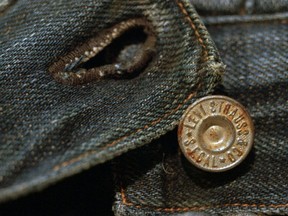 FILE- This March 12, 1997, file photo shows the top button on an approximately 100-year-old pair of jeans recently purchased by Levi Strauss & Co. for $25,000. The jeans were found in an abandoned mine, and are one of the two oldest-known pairs of Levi's in existence. The jeans were found in an abandoned mine. Levi Strauss & Co., which gave America its first pair of blue jeans, is going public for the second time on Thursday, March 21, 2019.