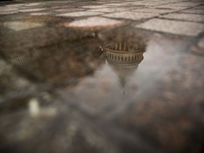 FILE- In this Feb. 22, 2019, file photo the dome of the U.S. Capitol Building is visible in reflection in Washington. On Friday, March 22, the Treasury Department releases federal budget data for February.