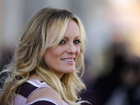 FILE - In this Oct. 11, 2018, file photo, adult film actress Stormy Daniels attends the opening of the adult entertainment fair 'Venus' in Berlin, Germany. Daniels says she's "saddened but not shocked" over the arrest of her former attorney, Michael Avenatti. Daniels issued a statement Monday, March 25, 2019, on Twitter saying she fired Avenatti a month ago after "discovering that he had dealt with me extremely dishonestly." She said she wouldn't elaborate. Avenatti is best known for representing Daniels in lawsuits against President Donald Trump and has been charged with extortion in New York and bank and wire fraud in California.