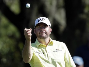 FILE - In this March 15, 2014, file photo, Robert Garrigus looks at his golf ball during the third round of the Valspar Championship golf tournament at Innisbrook in Palm Harbor, Fla. Garrigus has become the first player suspended by the PGA Tour for a drug of abuse. Garrigus says on Twitter he had a relapse and tested positive for marijuana, which is banned under the tour's anti-doping policy. He has been suspended for three months.