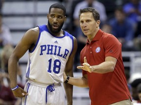FILE - In this July 7, 2015, file photo, Philadelphia 76ers' Deonte Burton (18) speaks with his summer league coach Billy Lange during the first half of an NBA summer league basketball game in Salt Lake City. Saint Joseph's University has hired Philadelphia 76ers assistant Billy Lange as its new basketball coach, the school said Thursday, March 28, 2019.  Lange succeeds longtime coach Phil Martelli, who was fired earlier this month after three straight losing seasons.