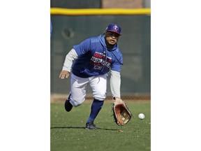 FILE - In this Monday, Feb. 18, 2019, file photo, Texas Rangers left fielder Willie Calhoun fields a ball during spring training baseball practice in Surprise, Ariz. Calhoun slimmed down quite a bit during the offseason. The 5-foot-8 player lost 24 pounds after changing his eating habits and committing to a fitness routine.