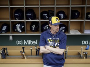 FILE - In this Saturday, March 2, 2019, file photo, Milwaukee Brewers manager Craig Counsell waits in the dugout for the start of a spring baseball game against the Chicago Cubs in Mesa, Ariz. The Brewers are well-positioned for more success this year after winning the NL Central and making it to the NL Championship Series last October.