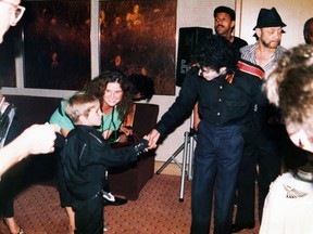 This image released by HBO shows a young Wade Robson shaking hands with pop icon Michael Jackson in 1987, in a scene from the documentary "Leaving Neverland." The unsparing documentary about Jackson and his alleged sexual abuse is already the third most-watched documentary of the past decade at the prime cable network, which takes pride in its documentary schedule. The Nielsen company said the first half of the four-hour program has been seen by 3.67 million people.