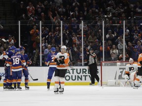 New York Islanders, left, celebrate a goal by Scott Mayfield during the first period of an NHL hockey game against the Philadelphia Flyers Saturday, March 9, 2019, in Uniondale, N.Y.