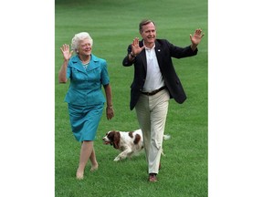 FILE - In this Aug. 24, 1992, file photo, President George H.W. Bush and first lady Barbara Bush walk with their dog Millie across the South Lawn as they return to the White House. Four months after the death of the former president, George H.W. Bush's office in Houston is to close for the last time at 5 p.m. Friday, March 29, 2019.