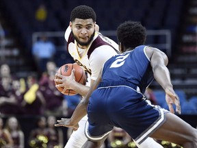 Iona guard E.J. Crawford, left, moves the ball against Monmouth forward Melik Martin during the first half of the championship NCAA college basketball game during the Metro Atlantic Athletic Conference tournament, Monday, March 11, 2019, in Albany, N.Y.