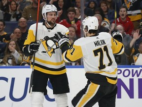 Pittsburgh Penguins defenseman Brian Dumoulin (8) and forward Evgeni Malkin (71) celebrate a goal during the second period of the team's NHL hockey game against the Buffalo Sabres, Thursday, March 14, 2019, in Buffalo, N.Y.