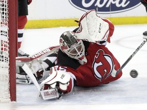 New Jersey Devils goaltender Cory Schneider tries to stop a scoring shot by Boston Bruins center Patrice Bergeron during the first period of an NHL hockey game Thursday, March 21, 2019, in Newark, N.J.