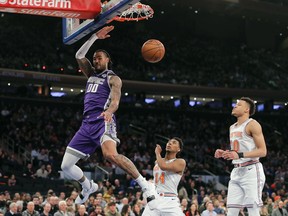 Sacramento Kings center Willie Cauley-Stein (00) dunks the ball ahead of New York Knicks guard Allonzo Trier (14) and forward Kevin Knox (20) during the second quarter of an NBA basketball game, Saturday, March 9, 2019, in New York.