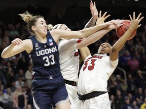 Connecticut guard Katie Lou Samuelson (33) knocks the ball from Louisville forward Sam Fuehring, center, and Louisville forward Bionca Dunham (33)  during the first half of a regional championship final in the NCAA women's college basketball tournament, Sunday, March 31, 2019, in Albany, N.Y.