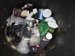 A plastic water bottle and plastic bags are seen discarded with other garbage in a corner trash can in the East Village neighborhood of Manhattan, Wednesday, March 27, 2019 in New York. Two New York lawmakers say Wednesday that they're optimistic that a ban on single-use plastic shopping bags could be included in the spending plan that's due Sunday.