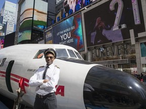 An actor dressed as a pilot from the 1960s and 70s poses for a photo next to a Lockheed Constellation L-1649A Starliner, known as the "Connie, is parked in New York's Times Square during a promotional event, Saturday, March 23, 2019, in New York. The vintage commercial airplane will serve as the cocktail lounge outside the TWA Hotel at JFK airport, a hotel that promises to bring back "the magic of the Jet Age."