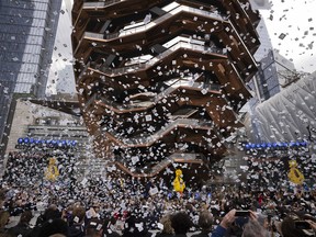 Confetti swirls around "Vessel" on its opening day at Hudson Yards, Friday, March 15, 2019, in New York. Hudson Yards, a $25 billion urban complex on Manhattan's west side, is the city's most ambitious development since the rebuilding of the World Trade Center. When fully complete, the 28-acre site will include 16 towers of homes and offices, a hotel, a school, the highest outdoor observation deck in the Western Hemisphere, a performing arts center, Vessel and a shopping mall.