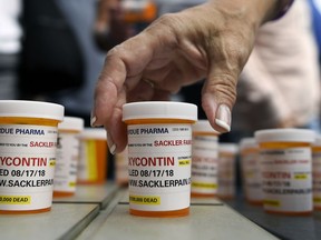 FILE - In this Aug. 17, 2018 file photo, family and friends who have lost loved ones to OxyContin and opioid overdoses leave pill bottles in protest outside the headquarters of Purdue Pharma, which is owned by the Sackler family, in Stamford, Conn. New York is suing the billionaire family behind Oxycontin, alleging the drugmaker fueled the opioid crisis by putting hunger for profits over patient safety.