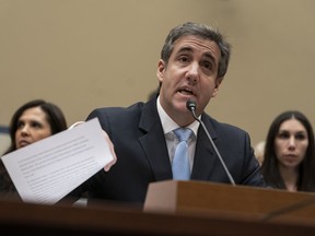 FILE - In this Wednesday, Feb. 27, 2019 file photo, Michael Cohen, President Donald Trump's former personal lawyer, reads an opening statement as he testifies before the House Oversight and Reform Committee on Capitol Hill in Washington. Cohen says he's cooperating with federal prosecutors in New York and hopes to receive a so-called Rule 35 motion from prosecutors that would reduce the time he is to spend in prison.