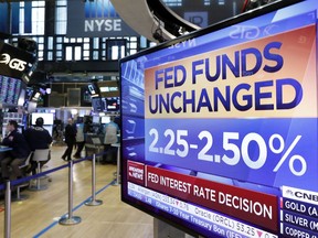A screen on the floor of the New York Stock Exchange shows the rate decision of the Federal Reserve, Wednesday, March 20, 2019. The Federal Reserve is leaving its key interest rate unchanged and projecting no rate hikes in 2019, dramatically underscoring its plan to be "patient" about any further increases.