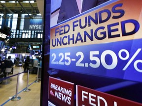 A screen on the floor of the New York Stock Exchange shows the rate decision of the Federal Reserve, Wednesday, March 20, 2019. The Federal Reserve is leaving its key interest rate unchanged and projecting no rate hikes in 2019, dramatically underscoring its plan to be "patient" about any further increases.