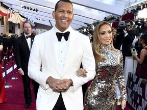 FILE - In this Sunday, Feb. 24, 2019, file photo, Alex Rodriguez, left, and Jennifer Lopez arrive at the Oscars at the Dolby Theatre in Los Angeles. Rodriguez and Lopez are engaged. The couple posted an Instagram photo of their hands with a massive engagement ring on Lopez's ring finger.