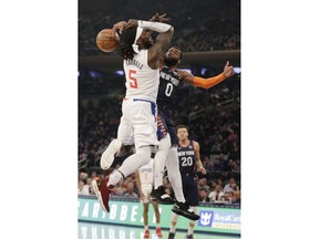 New York Knicks guard Kadeem Allen (0), right, fouls Los Angeles Clippers forward Montrezl Harrell (5) who drives to the basket during the first half of an NBA basketball game, Sunday, March 24, 2019, in New York.