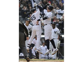 New York Yankees' Luke Voit, left, celebrates his three-run home run with Aaron Judge during the first inning of an opening-day baseball game against the Baltimore Orioles at Yankee Stadium, Thursday, March 28, 2019, in New York.