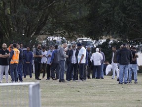 People wait for the start of funeral services in Christchurch, New Zealand, Wednesday, March 20, 2019.