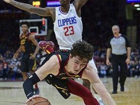 Cleveland Cavaliers' Cedi Osman falls to the floor after being fouled by Los Angeles Clippers' Lou Williams (23) in the first half of an NBA basketball game, Friday, March 22, 2019, in Cleveland.