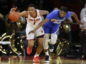 Miami (Ohio) guard Nike Sibande (1) and Buffalo guard Dontay Caruthers, right, chase a loose ball during the first half of an NCAA college basketball game, Friday, March 1, 2019, in Oxford, Ohio.