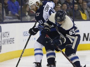Winnipeg Jets' Kyle Connor, left, and Columbus Blue Jackets' Markus Nutivaara, of Finland, fight for the puck during the first period of an NHL hockey game Sunday, March 3, 2019, in Columbus, Ohio.
