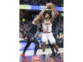 Cleveland Cavaliers guard Collin Sexton drives to the basket between Detroit Pistons guard Bruce Brown and center Andre Drummond in the first half of an NBA basketball game, Monday, March 18, 2019, in Cleveland.