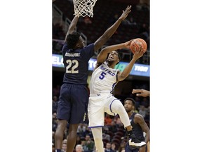 Buffalo's CJ Massinburg (5) drives to the basket against Akron's Emmanuel Olojakpoke (22) during the first half of an NCAA college basketball game at the Mid-American Conference tournament, Thursday, March 14, 2019, in Cleveland.
