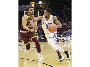 Buffalo's CJ Massinburg (5) drives past Central Michigan's Kevin McKay (20) during the first half of an NCAA college basketball game in the semifinals of the Mid-American Conference men's tournament Friday, March 15, 2019, in Cleveland.