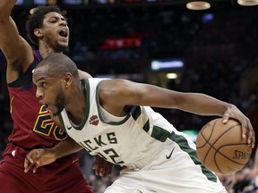 Milwaukee Bucks' Khris Middleton (22) drives past Cleveland Cavaliers' Brandon Knight during the first half of an NBA basketball game Wednesday, March 20, 2019, in Cleveland.