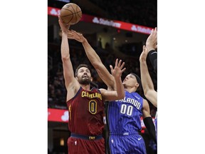Cleveland Cavaliers' Kevin Love (0) shoots against Orlando Magic's Aaron Gordon (00) in the first half of an NBA basketball game, Sunday, March 3, 2019, in Cleveland.