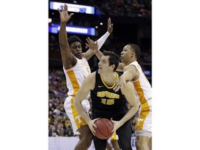Iowa's Ryan Kriener, center, drives between Tennessee's Admiral Schofield, left, and Grant Williams in the first half during a second round men's college basketball game in the NCAA Tournament in Columbus, Ohio, Sunday, March 24, 2019.