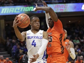 Buffalo's Davonta Jordan (4) passes against Bowling Green's Daeqwon Plowden (25) during the first half of an NCAA college basketball championship game of the Mid-American Conference men's tournament, Saturday, March 16, 2019, in Cleveland.