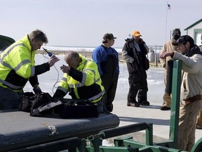 Fisherman James Gibelyou,  left, watches a rescue crew on a airboat prepare to go back on the ice to rescue stranded fishermen off Catawba Island State Park, Ohio in Lake Erie, on Saturday, March 9, 2019. The Coast Guard and Ottawa County Sheriff's Office began receiving reports around early Saturday that a large number of people had become stuck on an ice floe that had broken off from the main ice pack connected to Catawba Island. Coast Guard Petty Officer Brian McCrum says 46 people were rescued, including two fishermen who were hoisted by helicopter and received medical assessments.