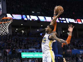 Oklahoma City Thunder center Steven Adams (12) blocks a shot by Golden State Warriors forward Alfonzo McKinnie (28) during the first half of an NBA basketball game Saturday, March 16, 2019, in Oklahoma City.