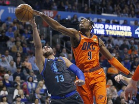 Oklahoma City Thunder forward Jerami Grant (9) reaches in to block a shot by Dallas Mavericks guard Jalen Brunson (13) in the first half of an NBA basketball game Sunday, March 31, 2019, in Oklahoma City.