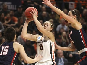 Oregon State's Mikayla Pivec (0) looks for a way through Gonzaga's Jessie Loera (15) and LeeAnne Wirth (4) during the first half of a second-round game of the NCAA women's college basketball tournament in Corvallis, Ore., Monday, March 25, 2019.