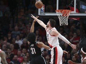 Brooklyn Nets center Jarrett Allen shoots next to Portland Trail Blazers center Jusuf Nurkic during the first half of an NBA basketball game in Portland, Ore., Monday, March 25, 2019.